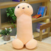 a pink penis plush that has the expression of laughing with book shelves in background