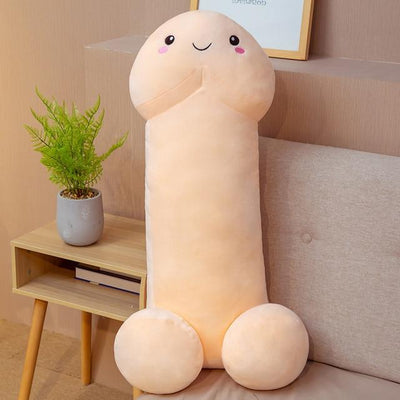 A smiling toy dick sitting on a couch with plant in background